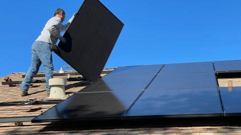 Op het dak van een bedrijvenpand worden zonnepanelen geplaatst