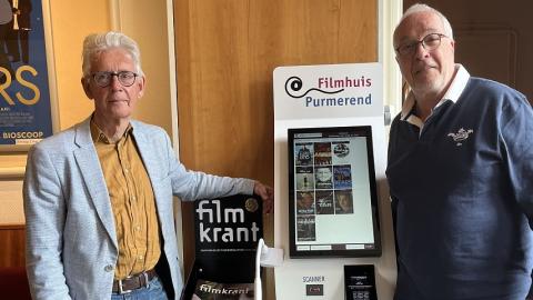 Voorzitter Jeroen Adolfs en Operateur Ron Schümaker naast de nieuwe kaartmachine filmhuis.