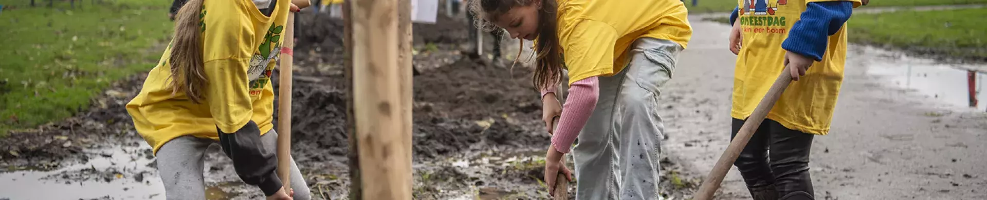 Schoolgaande kinderen planten een boom tijdens de Boomfeestdag