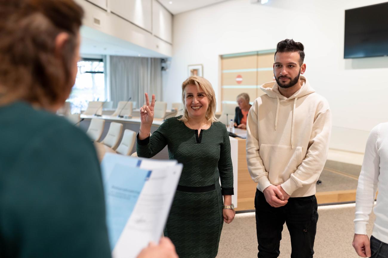 Burgemeester Selm met twee inwoners tijdens de ceremonie