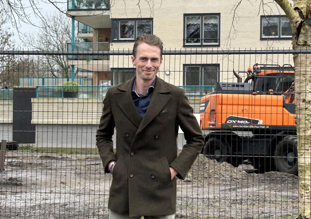 Omgevingsmanager Gilbert Zweedijk voor een bouwhek bij een bouwplaats