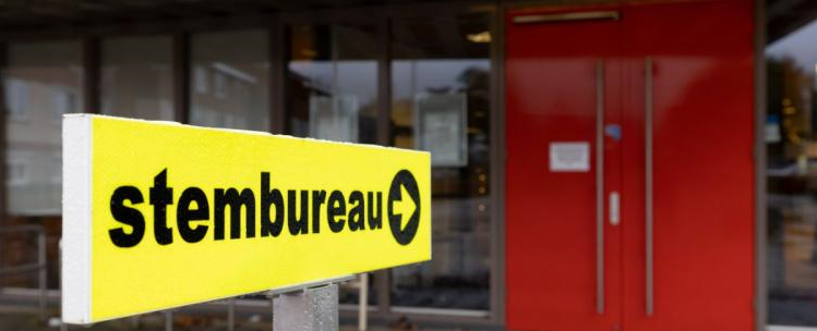 geel bord voor ingang stembureau met de tekst Stembureau en een pijl naar de ingang