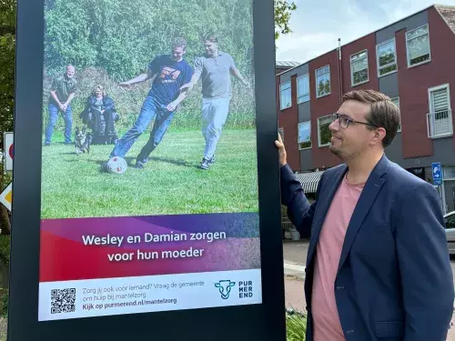 Wethouder Chris Boer bij één van de digitale reclameschermen bij de Beemsterbrug.