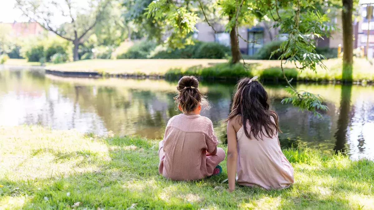 twee kinderen aan de oever in de schaduw