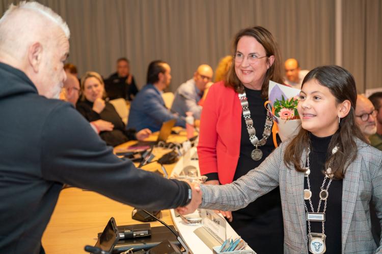 De kinderburgemeester schudt de handen van de gemeenteraad